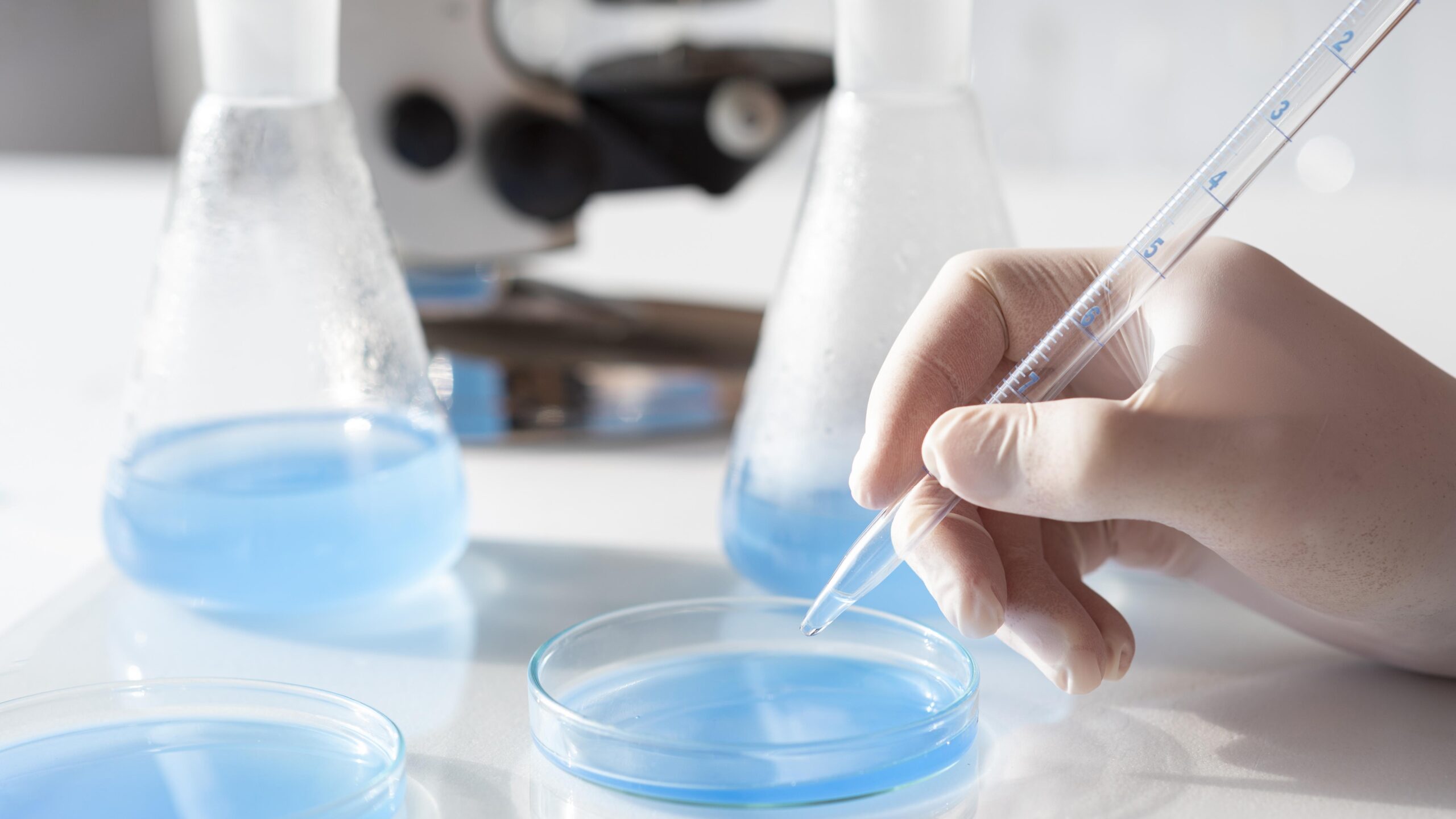 close up hand holding pipette scaled