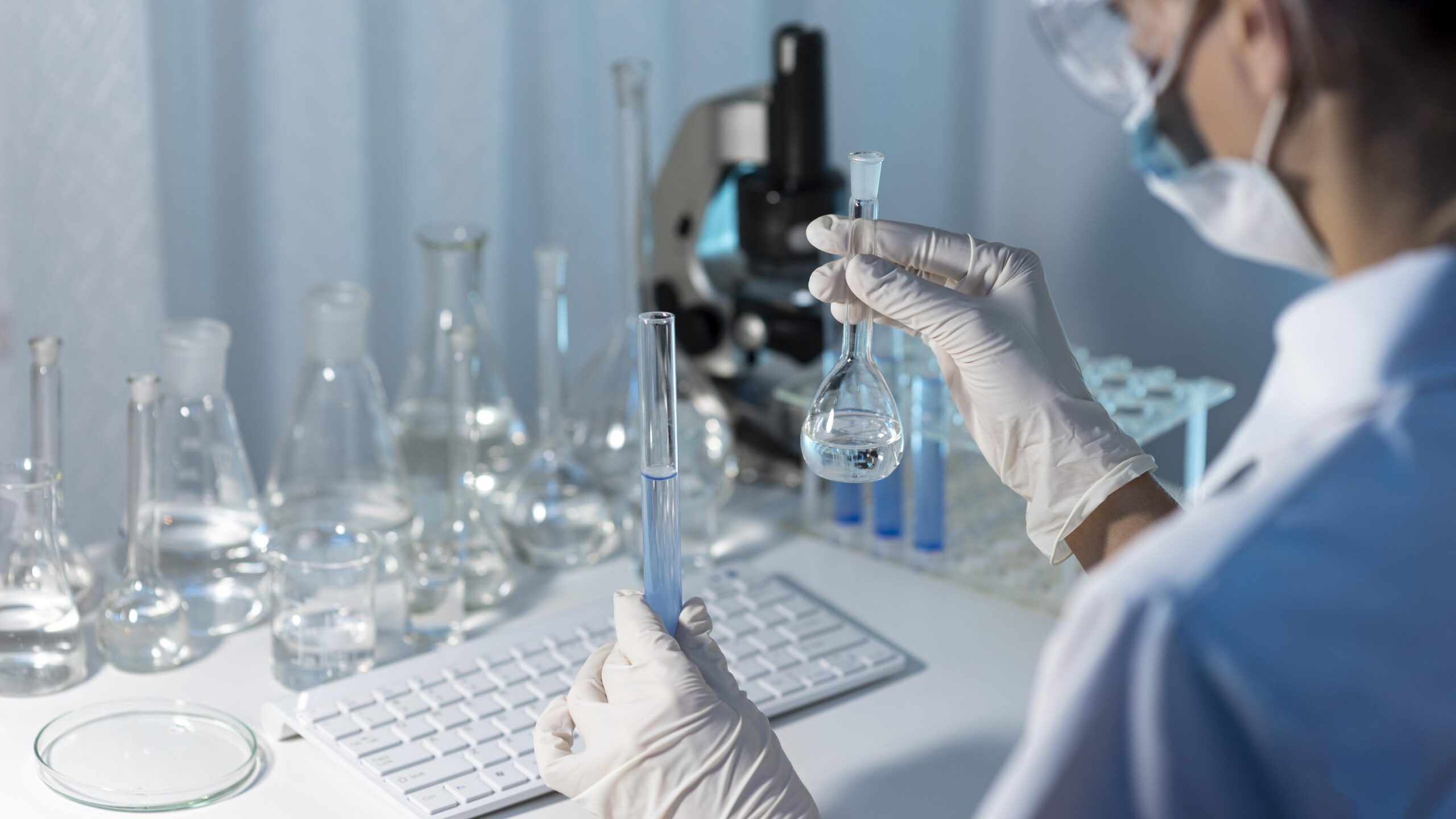 close up researcher holding glassware scaled